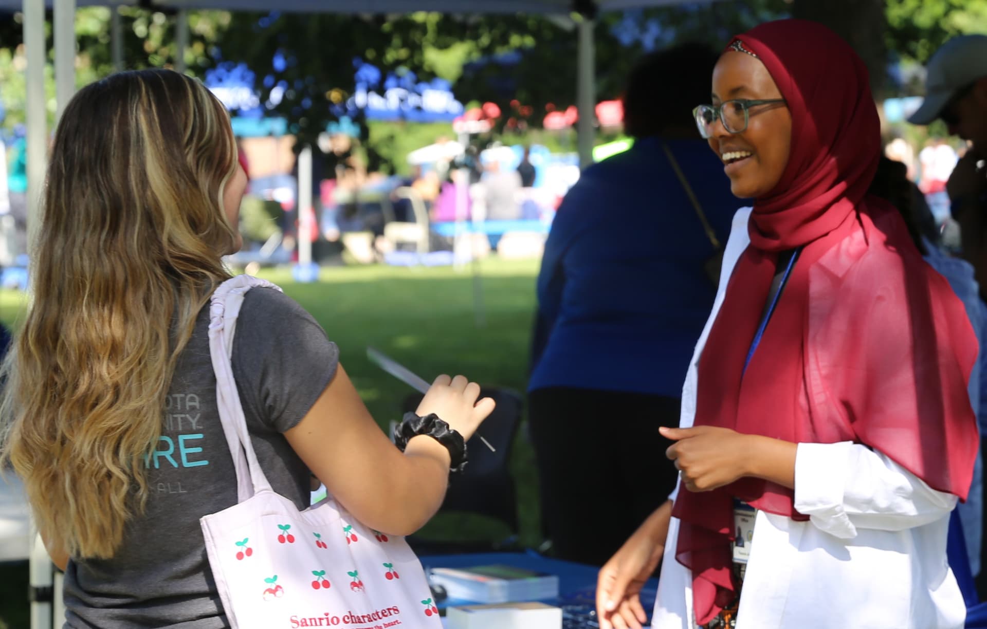 A DPS staff member smiling and talking to staff at an event.