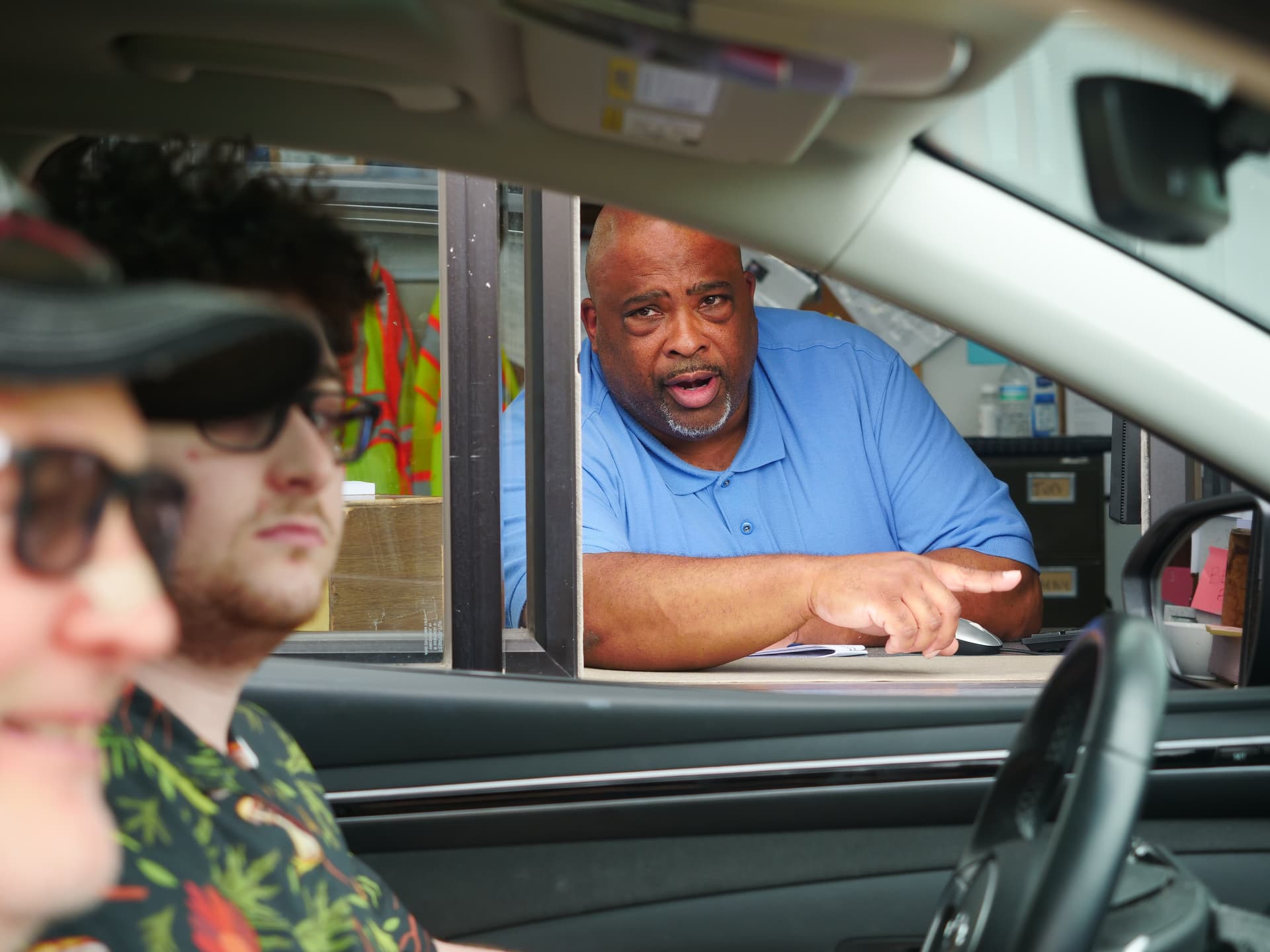 A staff member helps someone taking their driver's test.