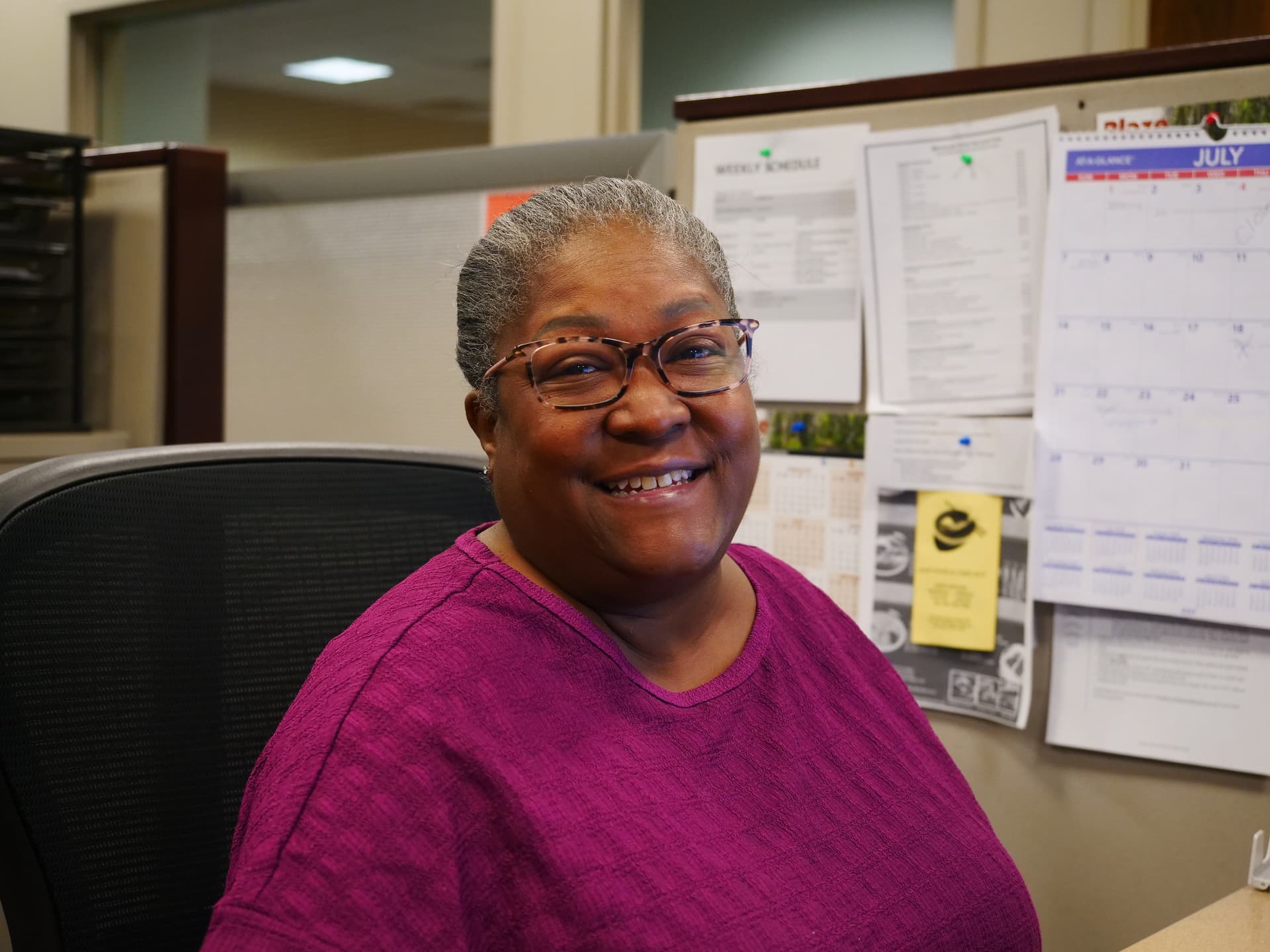 A female staff member smiles at the camera. 