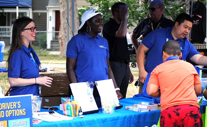 Three DPS staff members stand behind an event table