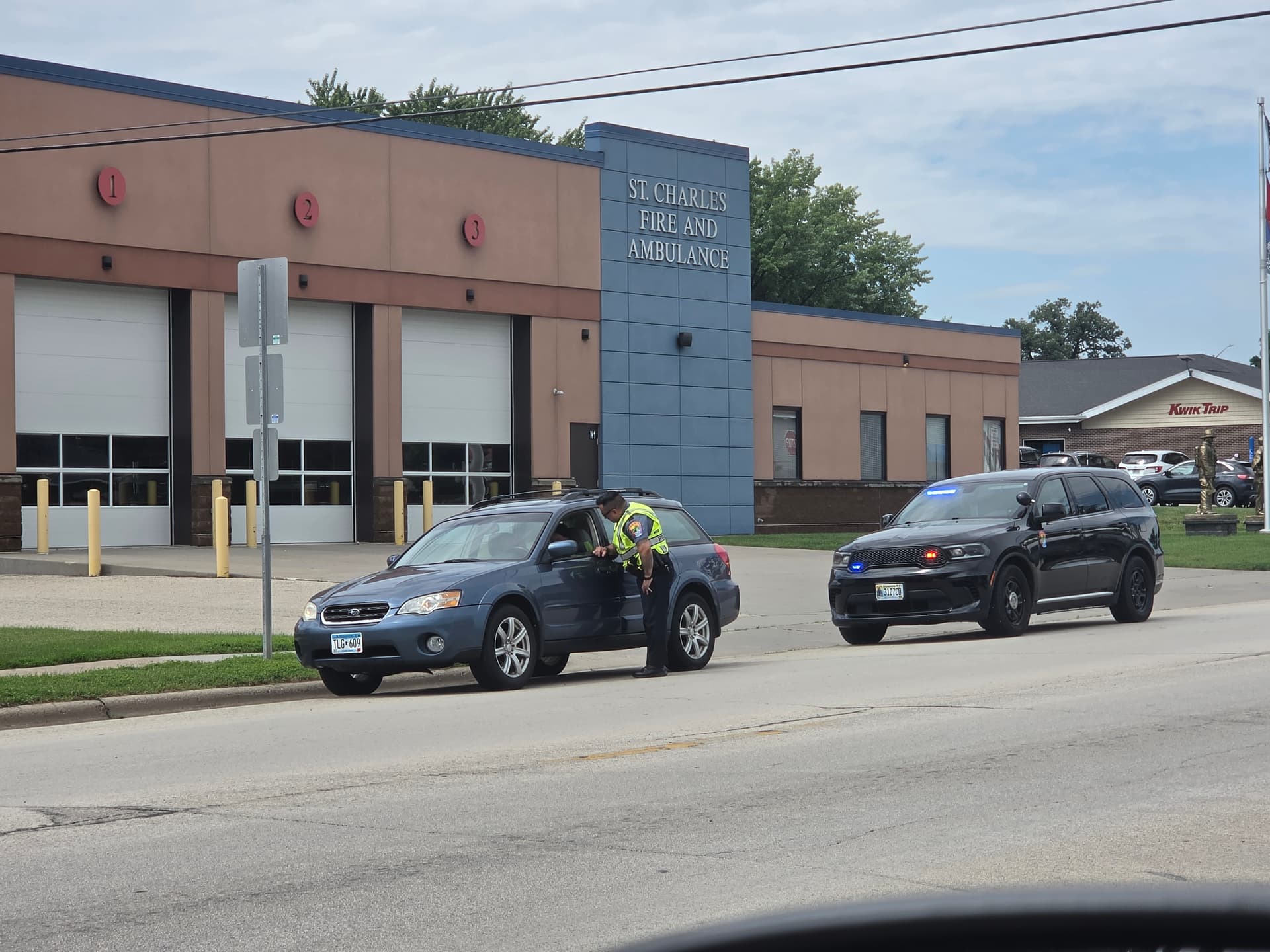 Police officer looks into a car while conducting a stop in St. Charles