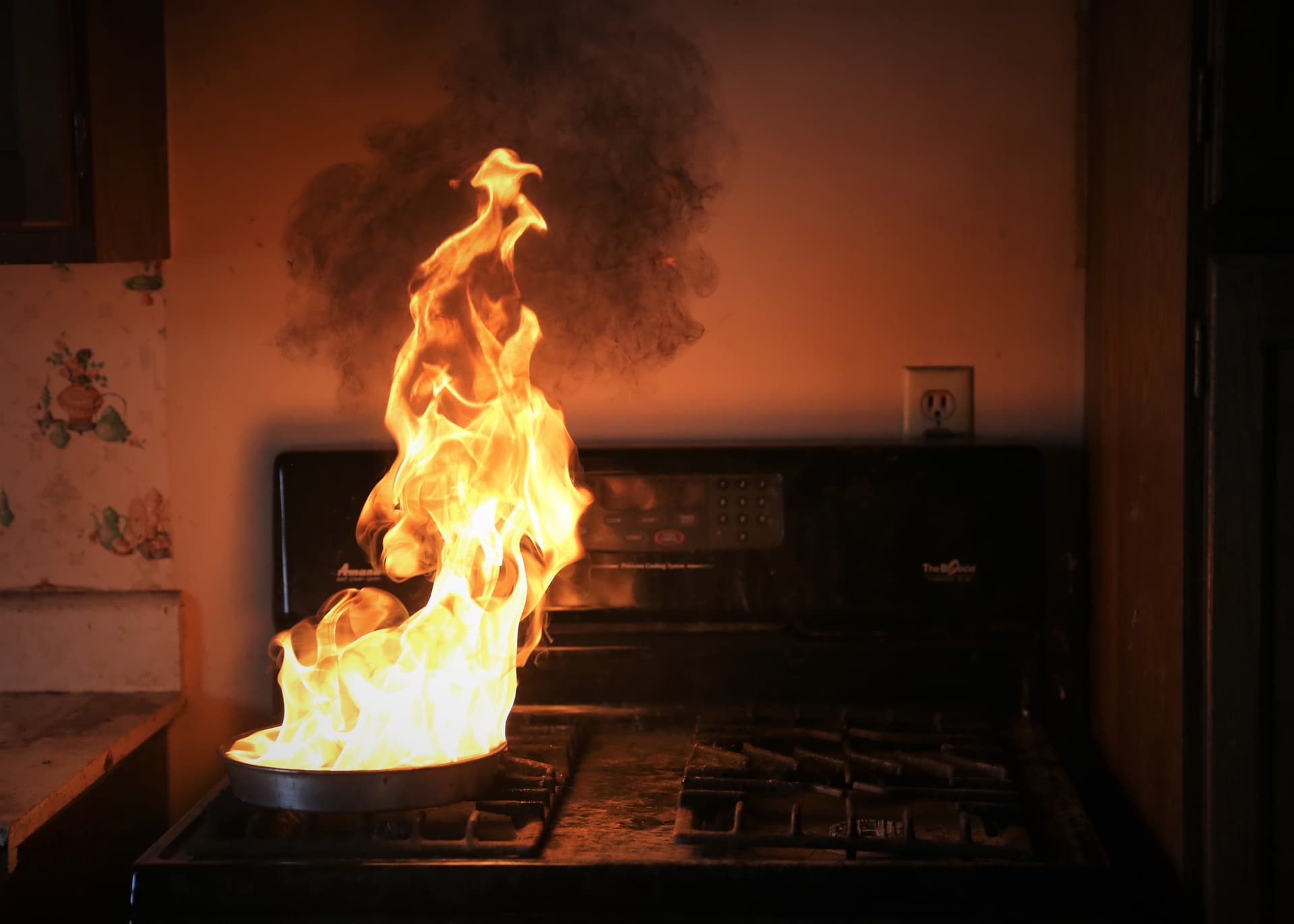 A pan on a stove is on fire.