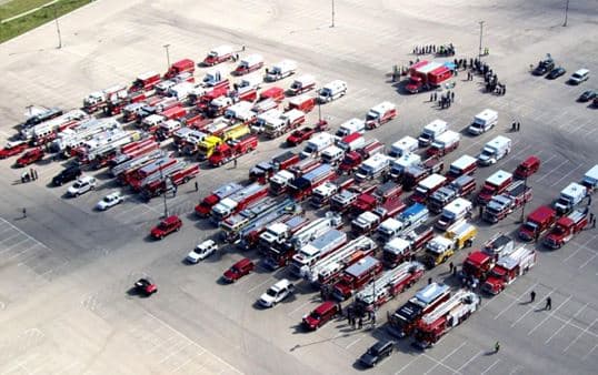 A fire truck parked in a gravel parking lot. 