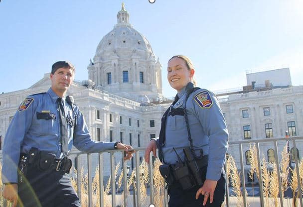 two capitol security officer smiling in front of Capitol